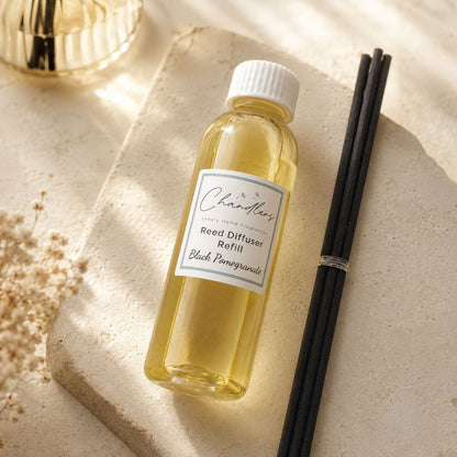 reed diffuser refill bottle with black reeds in a soft neutral home fragrance setting